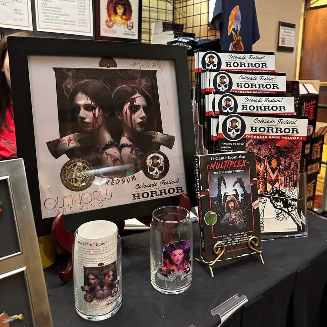 Image of Colorado Festival of Horror merchandise, pints glasses, books and print of twin girls with bloack hair by Xander Smith